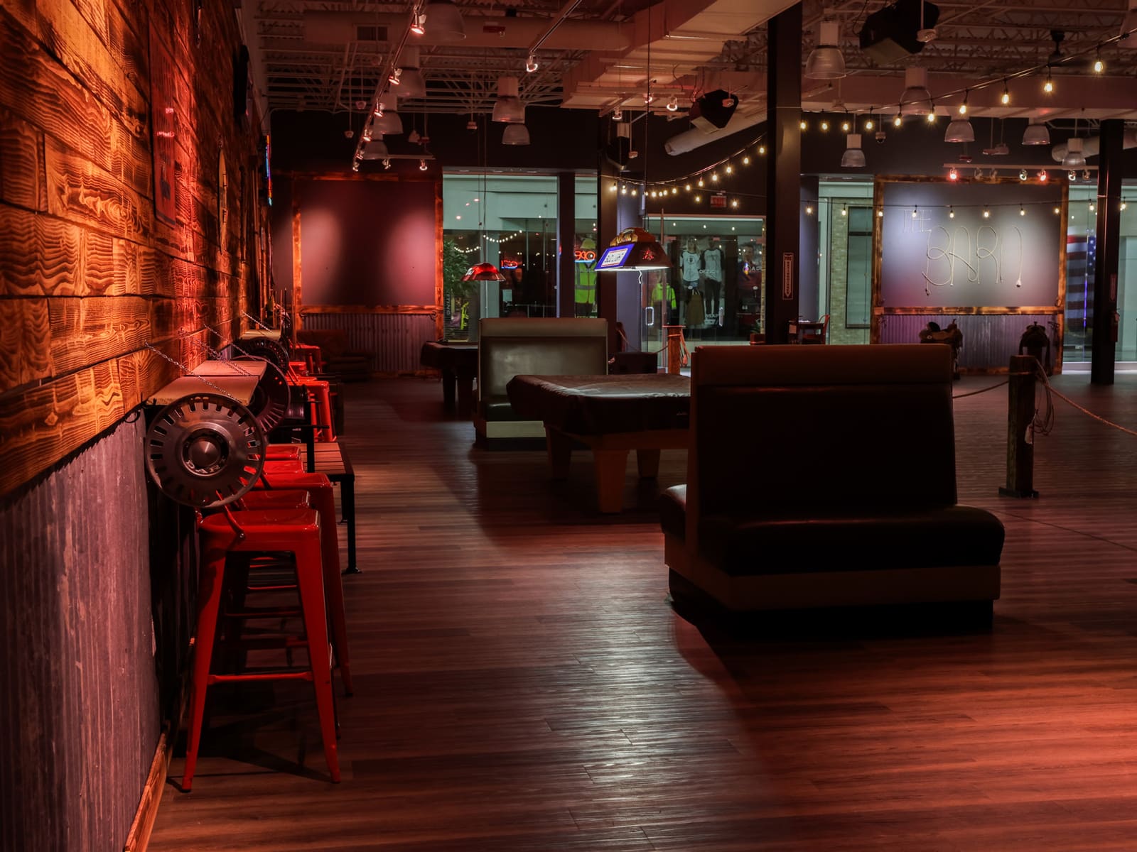 Lounge seating area with red barstools and The Barn sign